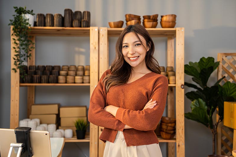 Portrait of Asian young woman pack order into box and look at ca